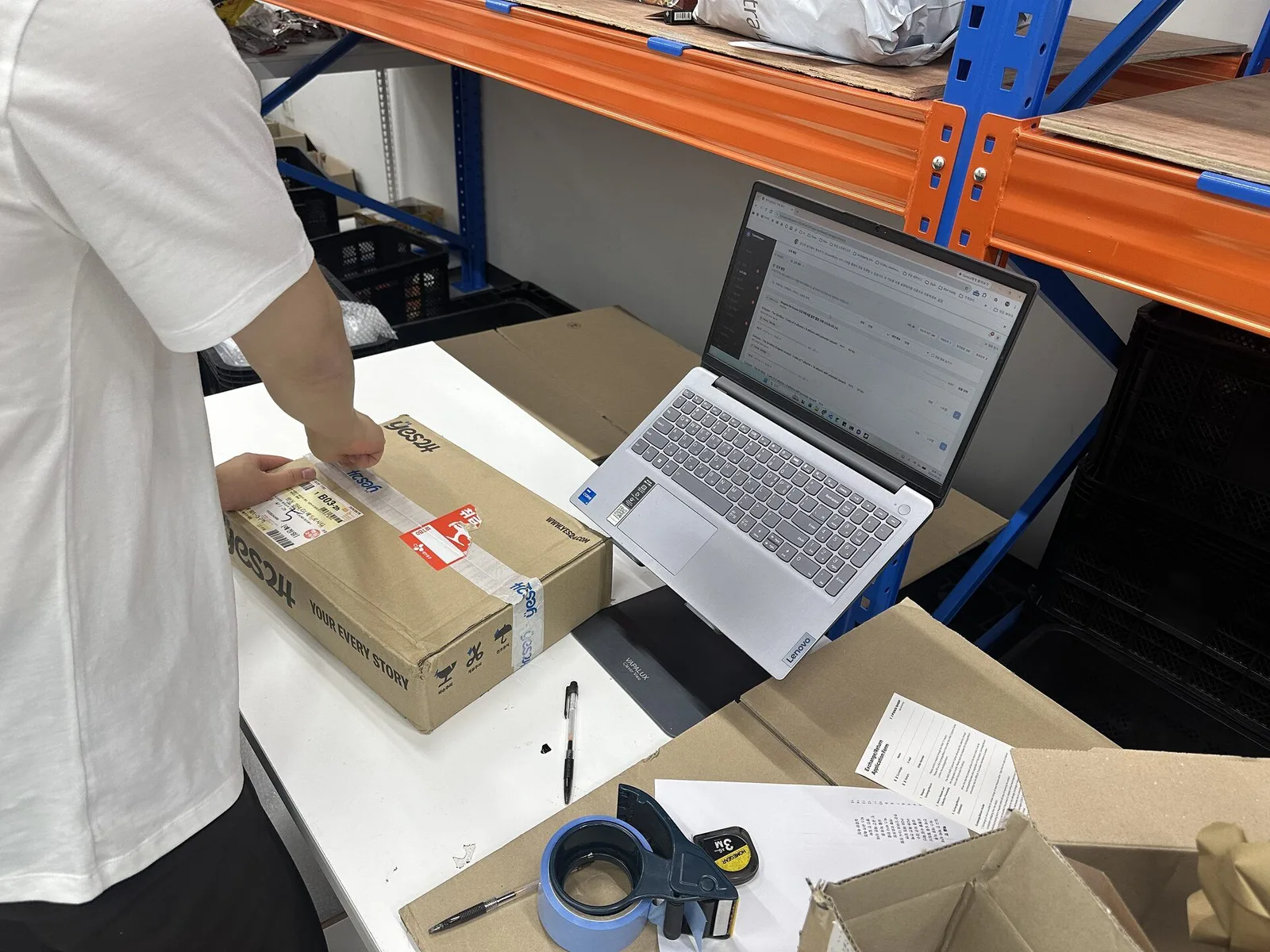 KIKIT staff opening a Korean seller parcel beside the digital order record