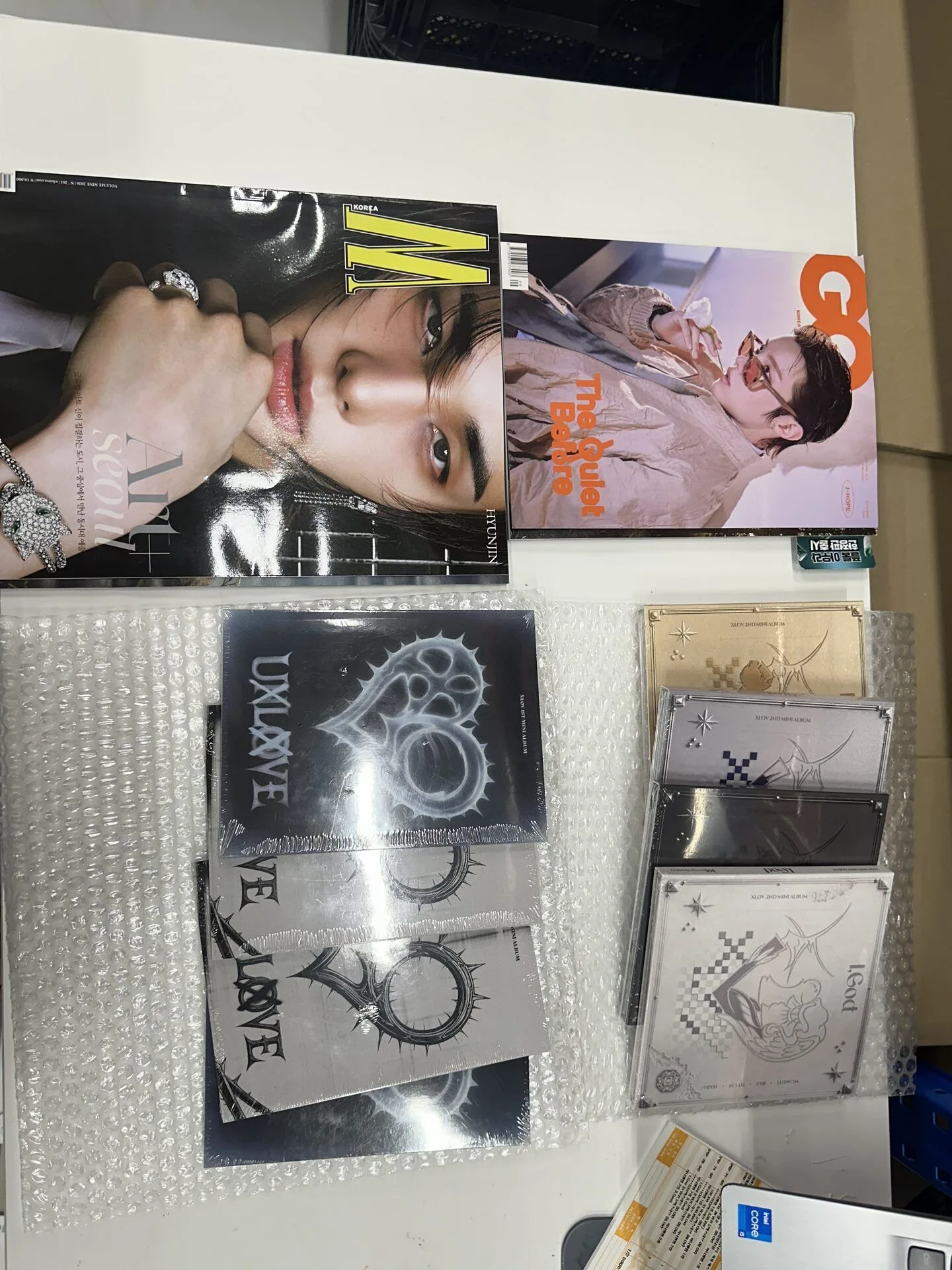 Assorted K-pop albums arranged on a table for order matching